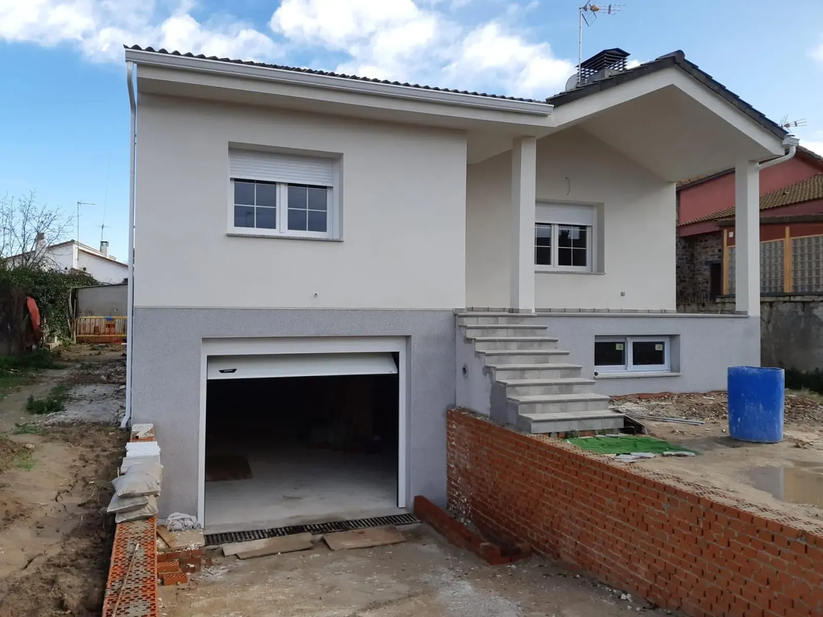 Vivienda de obra nueva acabada en monocapa china blanca con zócalo gris