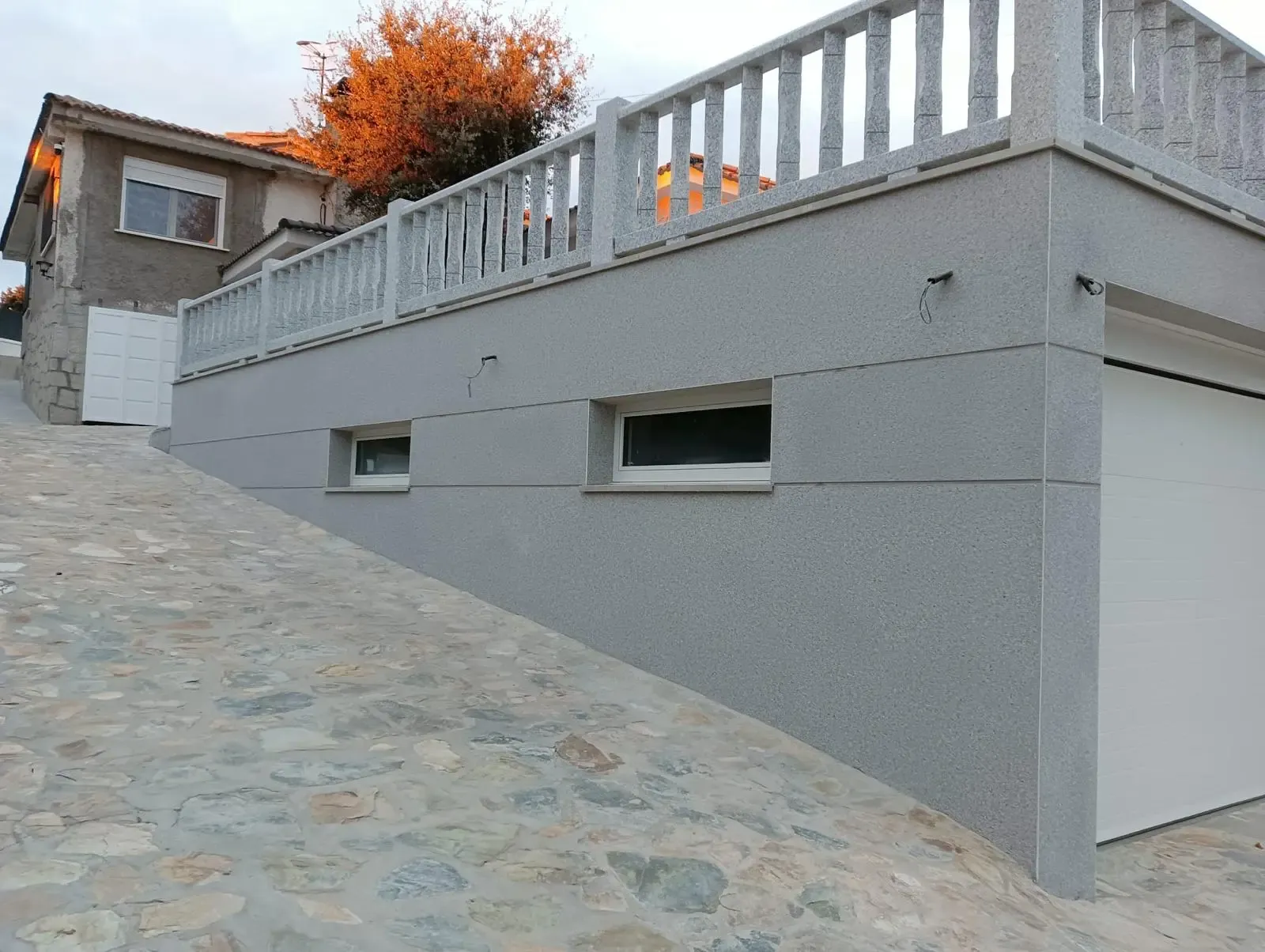 Lateral de la vivienda terminado con monocapa china gris