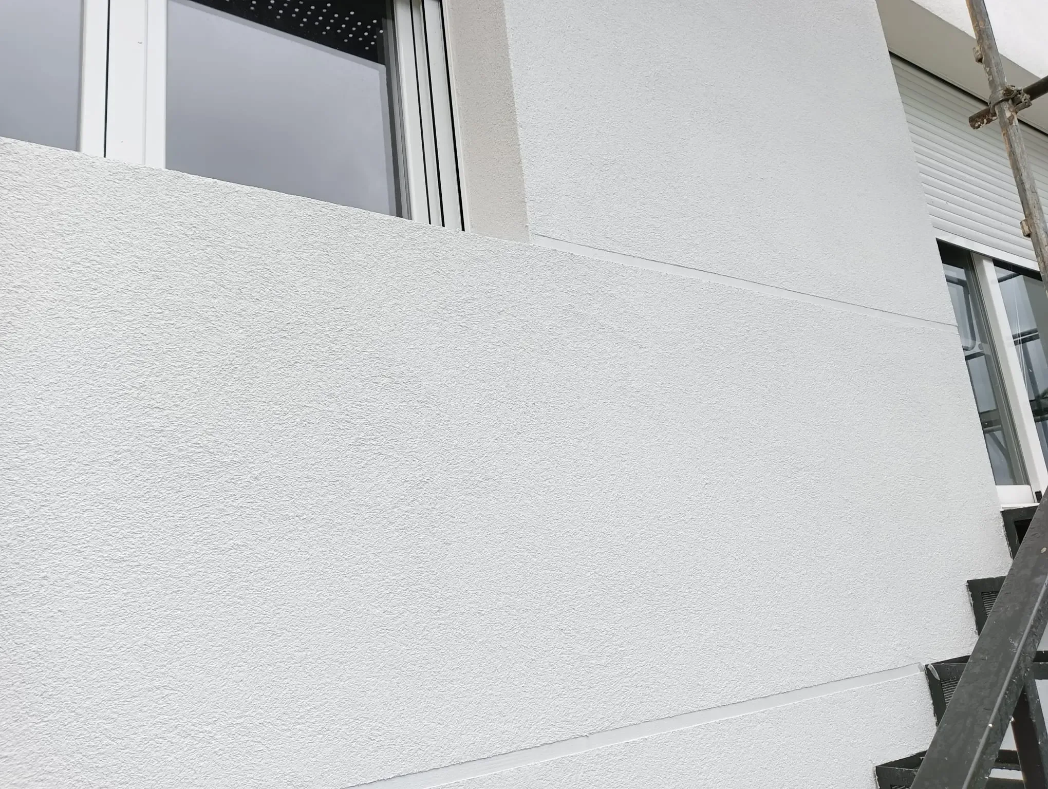 Detalle de la textura del acabado blanco junto a una ventana