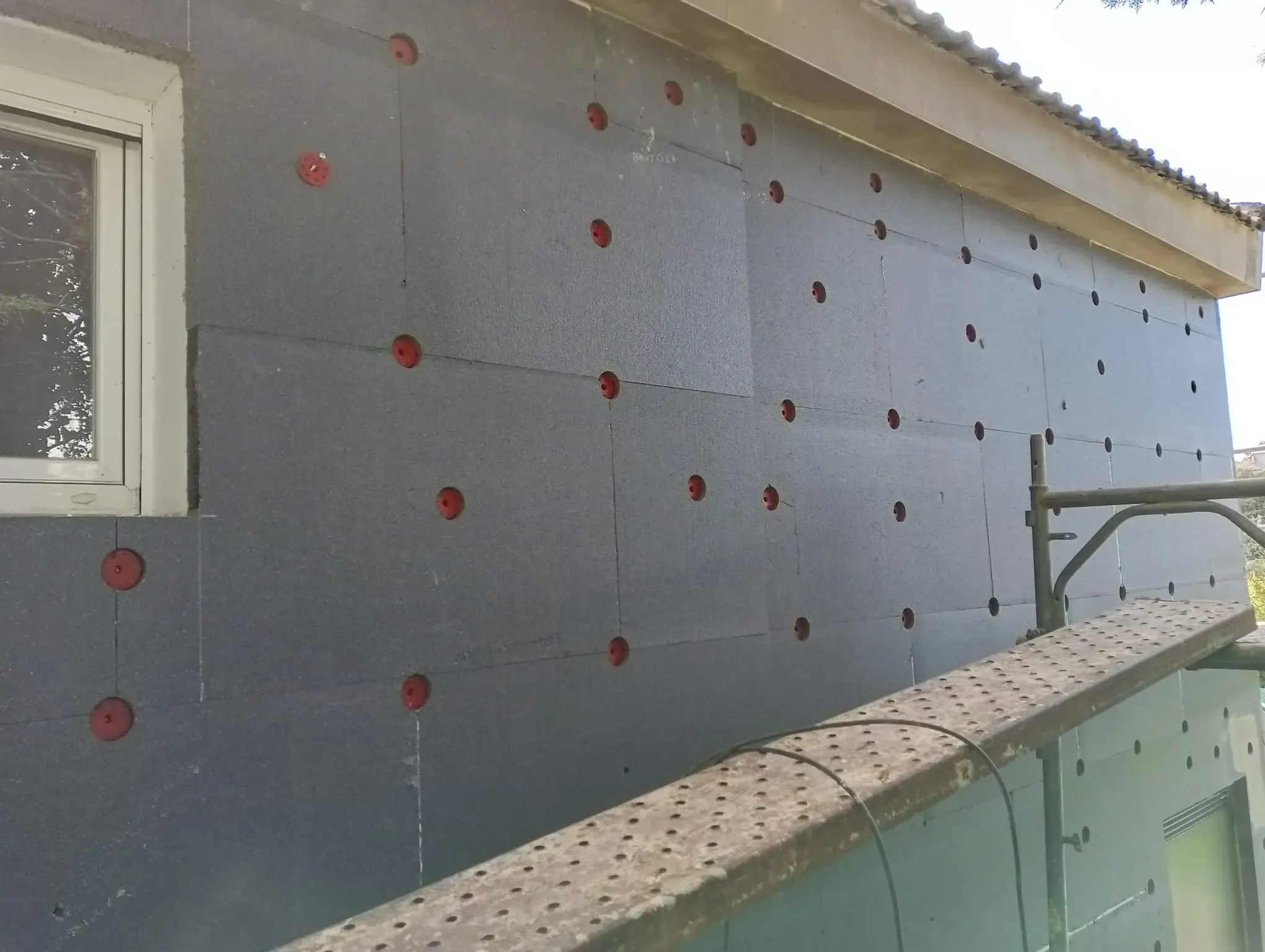 Planchas de aislante colocadas y fijadas con espigas antes del mortero base