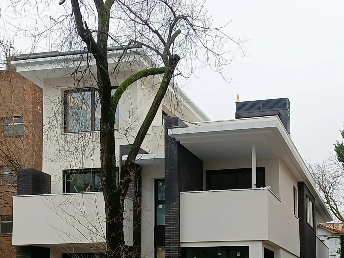 Encuentro entre los paños blancos y los voladizos de la vivienda